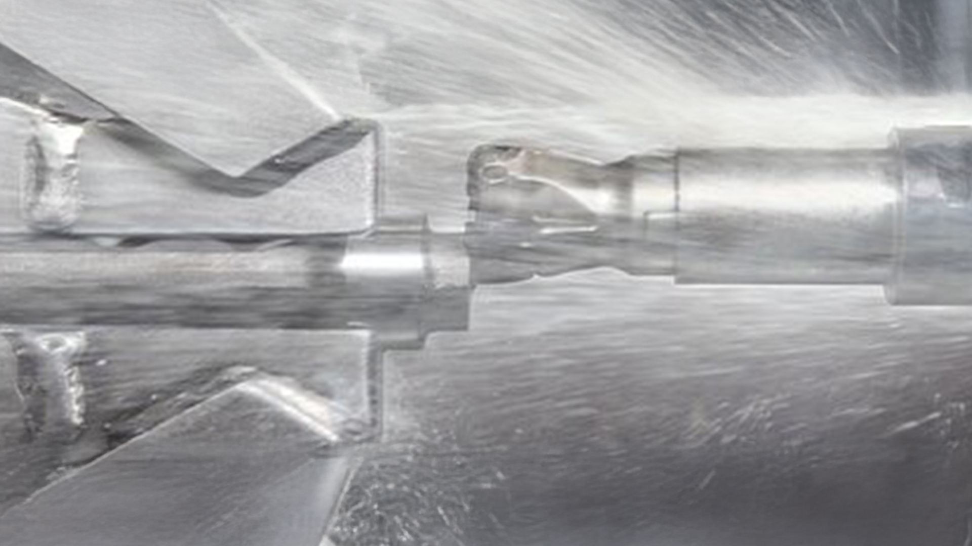 Präzise mechanische Bearbeitung: Metall wird mit einem Schneidwerkzeug und Kühlflüssigkeit bearbeitet.